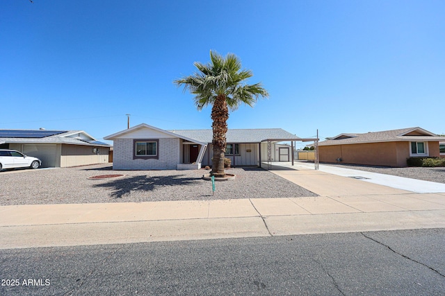 view of front of property with an attached carport, concrete driveway, and brick siding