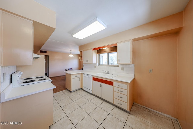 kitchen with a sink, under cabinet range hood, tasteful backsplash, white appliances, and light countertops