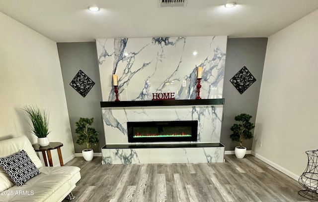 living room featuring hardwood / wood-style flooring and a high end fireplace