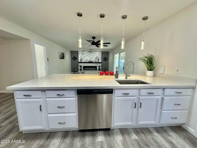 kitchen featuring sink, decorative light fixtures, dishwasher, kitchen peninsula, and white cabinets