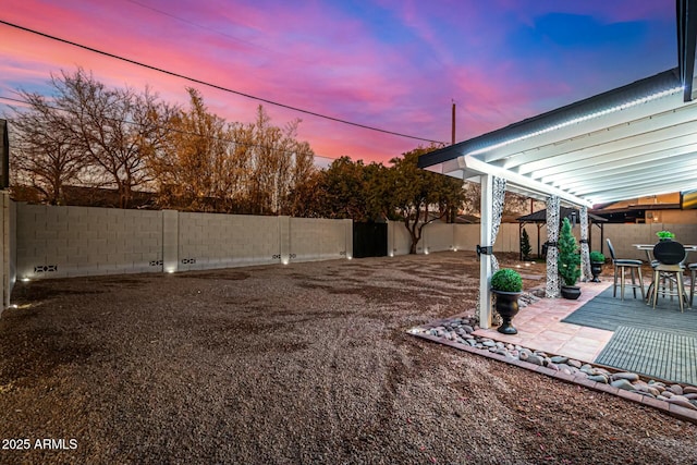 yard at dusk with a patio area