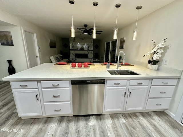 kitchen with sink, stainless steel dishwasher, hanging light fixtures, and white cabinets