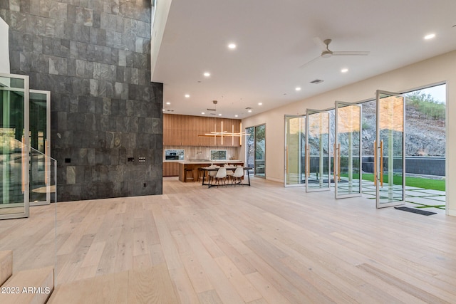 unfurnished living room featuring light hardwood / wood-style flooring and ceiling fan