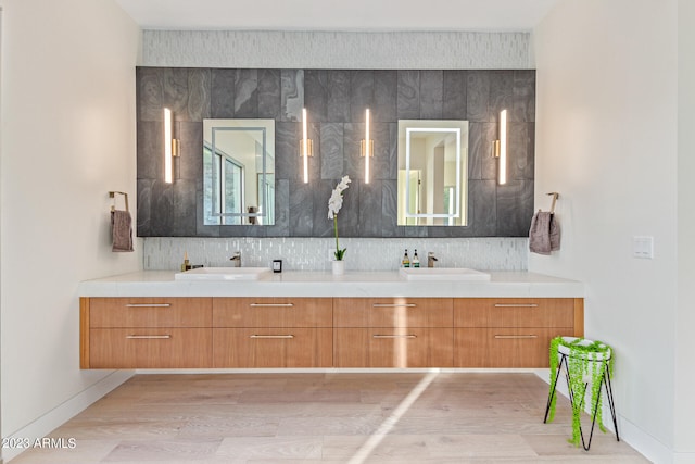 bathroom featuring dual bowl vanity, tasteful backsplash, and hardwood / wood-style flooring