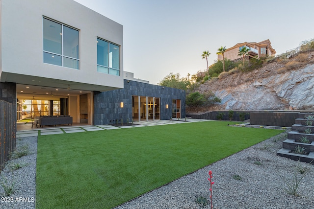 yard at dusk featuring a patio