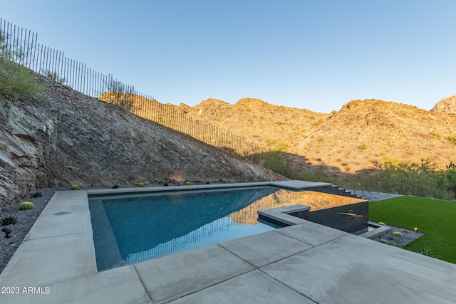 view of swimming pool featuring a mountain view and a patio