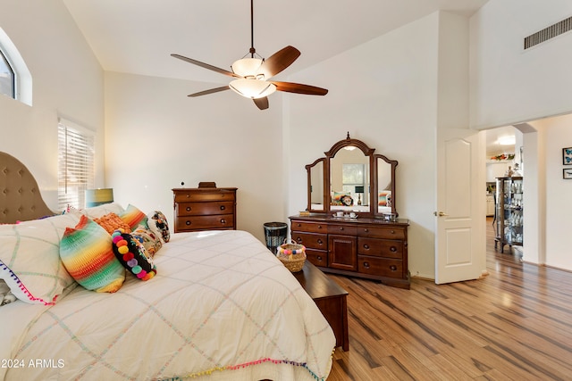 bedroom with light hardwood / wood-style flooring, high vaulted ceiling, and ceiling fan