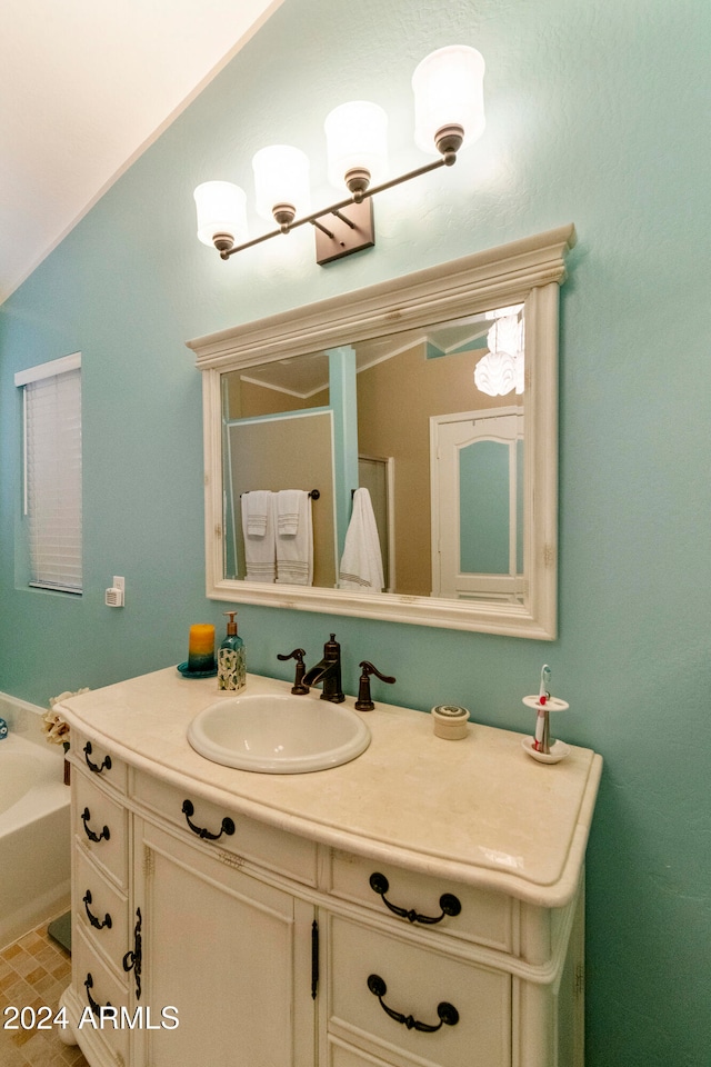 bathroom featuring vanity, a tub, and vaulted ceiling