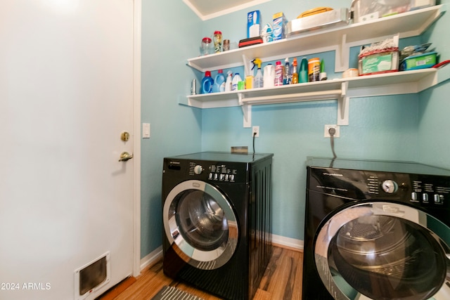 laundry area featuring ornamental molding, washer and dryer, and hardwood / wood-style floors