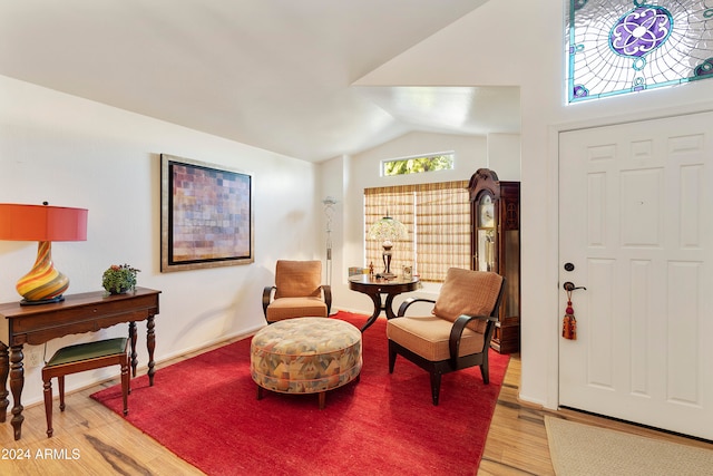 foyer featuring wood-type flooring and vaulted ceiling