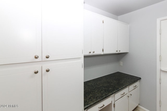 interior space featuring dark stone counters and white cabinets