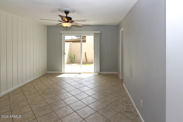 tiled empty room with a textured ceiling and ceiling fan