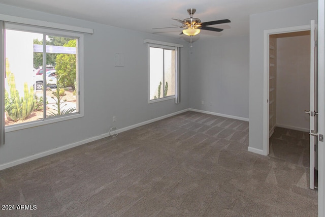 carpeted spare room featuring ceiling fan