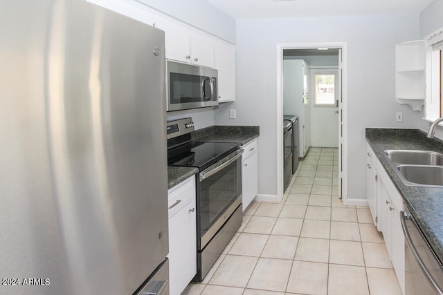 kitchen with stainless steel appliances, white cabinets, light tile patterned flooring, and sink