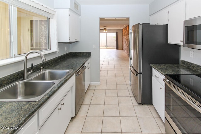 kitchen featuring white cabinetry, appliances with stainless steel finishes, light tile patterned floors, and sink