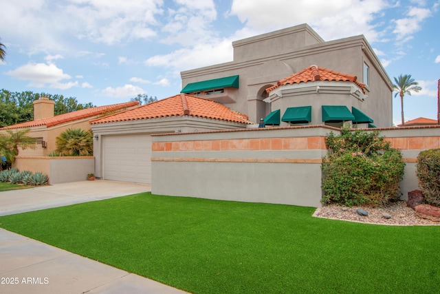 mediterranean / spanish home with a garage and a front lawn