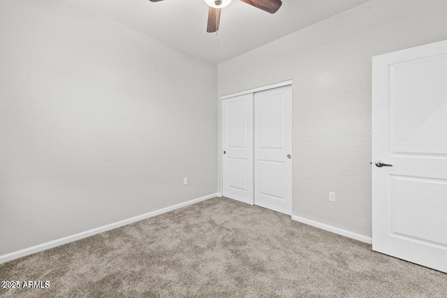 unfurnished bedroom featuring ceiling fan, a closet, carpet flooring, and baseboards