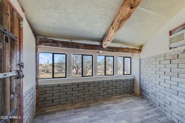 interior space featuring a textured ceiling and beamed ceiling