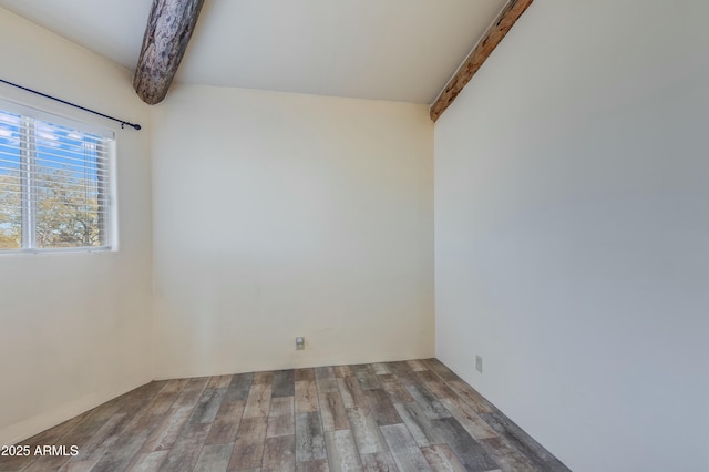 spare room with hardwood / wood-style floors and beam ceiling