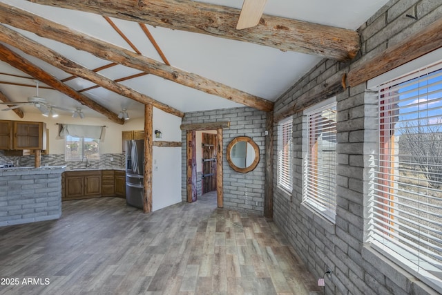 interior space featuring brick wall, decorative backsplash, and vaulted ceiling with beams