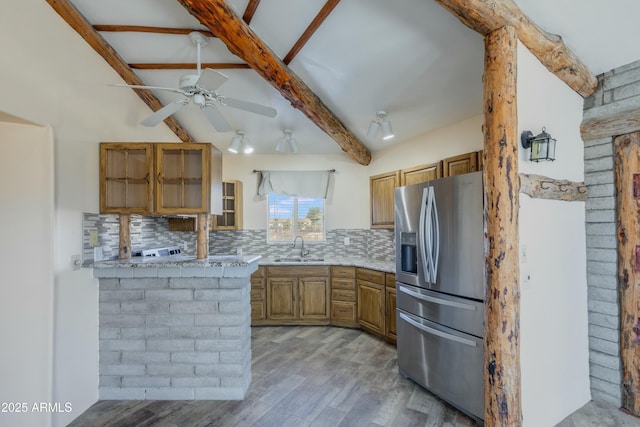 kitchen with sink, ceiling fan, light hardwood / wood-style floors, kitchen peninsula, and stainless steel fridge