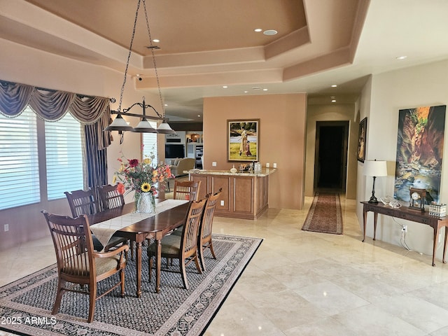 dining room with a raised ceiling