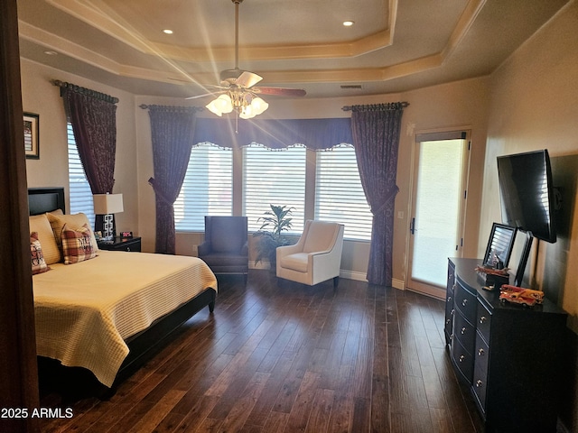 bedroom featuring a raised ceiling, ceiling fan, and dark hardwood / wood-style flooring