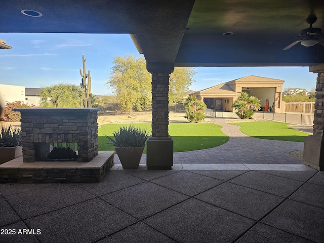 view of patio featuring ceiling fan and an outdoor stone fireplace