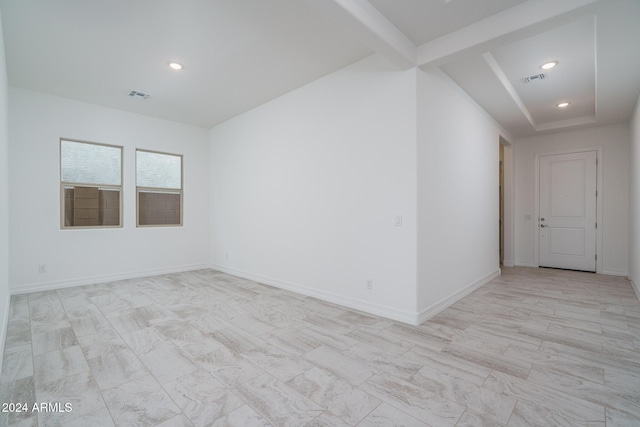 spare room featuring beamed ceiling