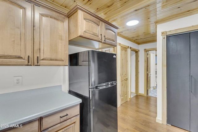 kitchen featuring light brown cabinetry, freestanding refrigerator, light wood-type flooring, light countertops, and wooden ceiling