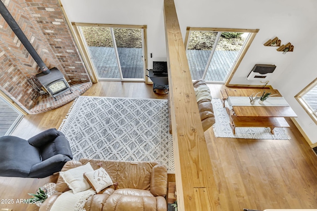 living area with a wood stove and wood finished floors