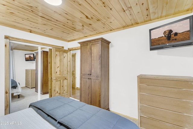 carpeted bedroom with a closet, wooden ceiling, and crown molding