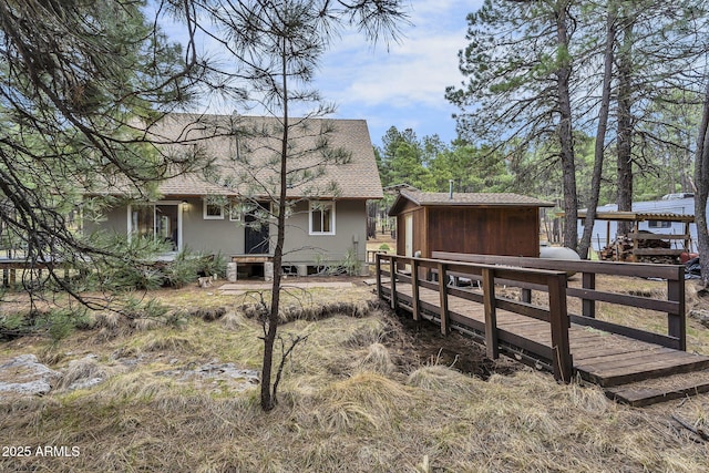 back of house featuring roof with shingles