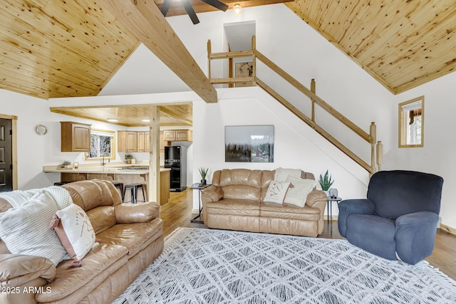 living area with stairs, wood ceiling, a ceiling fan, and light wood-style floors