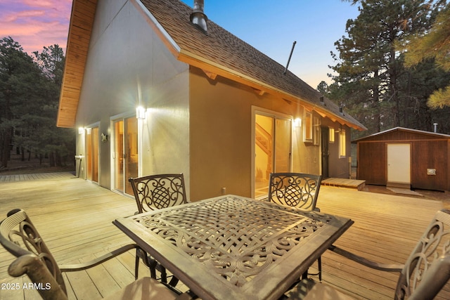 exterior space with an outdoor structure, outdoor dining space, and a storage shed