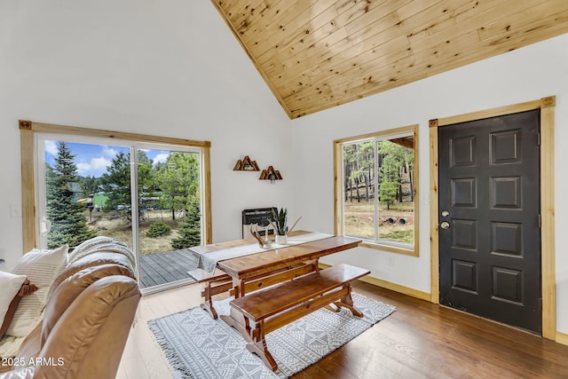 dining space featuring high vaulted ceiling, wood ceiling, baseboards, and wood-type flooring