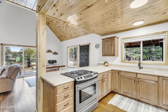 kitchen featuring a sink, light brown cabinets, a wealth of natural light, gas range, and wooden ceiling