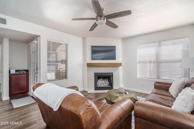 living room with a ceiling fan, baseboards, plenty of natural light, and wood finished floors