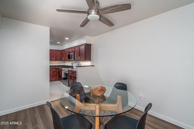 dining room featuring light wood-style floors, baseboards, and ceiling fan