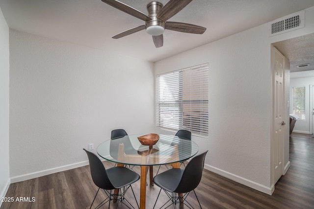 dining space with visible vents, wood finished floors, and baseboards