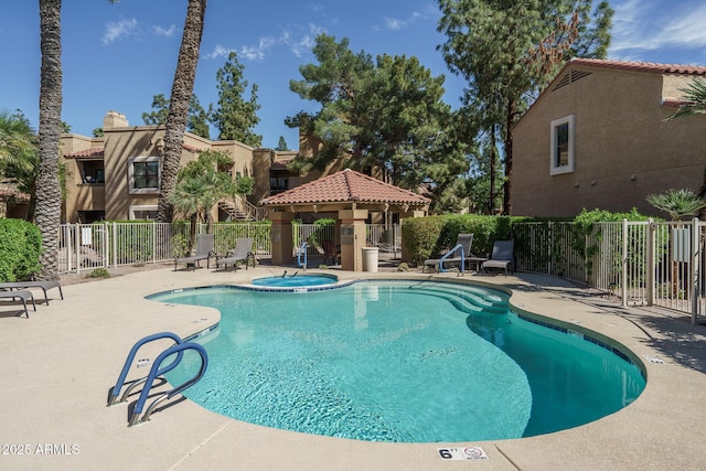 pool featuring fence, a hot tub, a gazebo, and a patio area