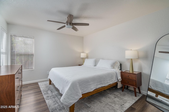 bedroom with dark wood-style flooring, baseboards, and a ceiling fan