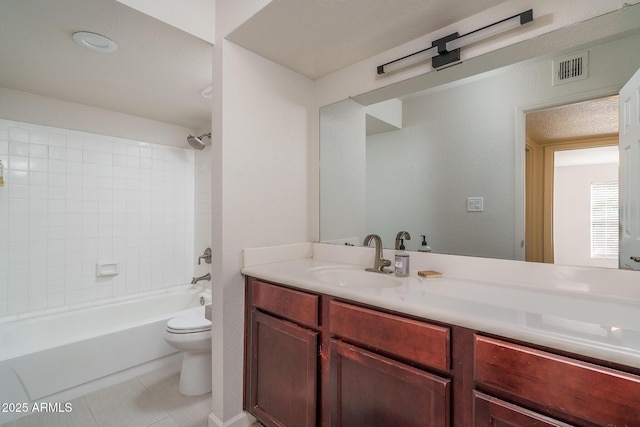 bathroom featuring toilet, vanity, visible vents, tile patterned floors, and tub / shower combination