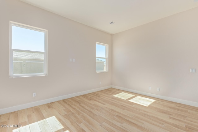 empty room with light wood finished floors and baseboards