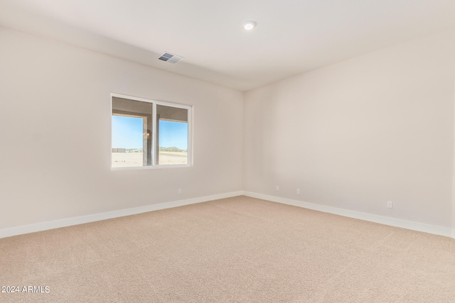 empty room with carpet floors, baseboards, and visible vents