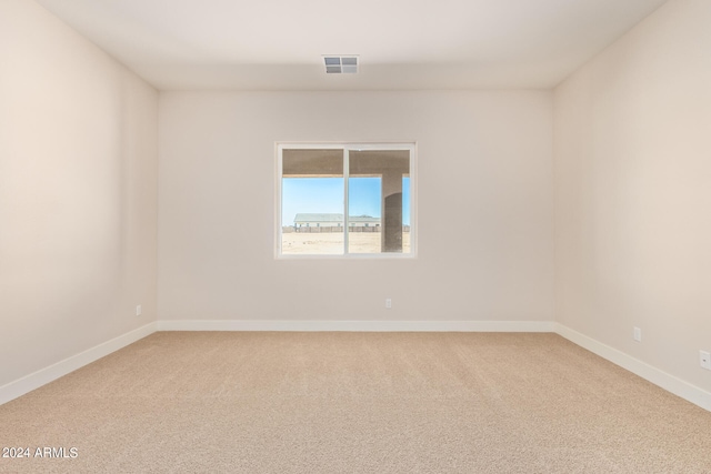 unfurnished room with carpet flooring, visible vents, and baseboards