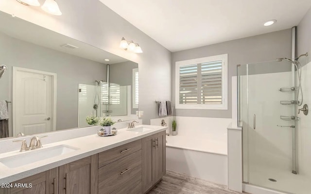 full bath featuring a garden tub, a sink, and a shower stall