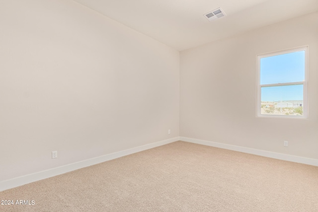 carpeted empty room featuring visible vents and baseboards