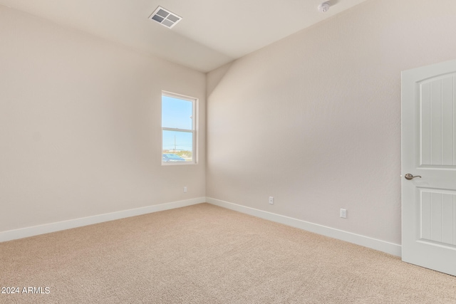 empty room with baseboards, visible vents, and light colored carpet