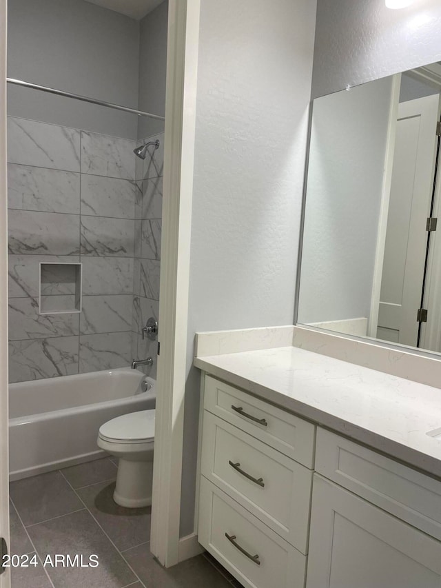 bathroom featuring a textured wall, toilet, tile patterned floors, tub / shower combination, and vanity